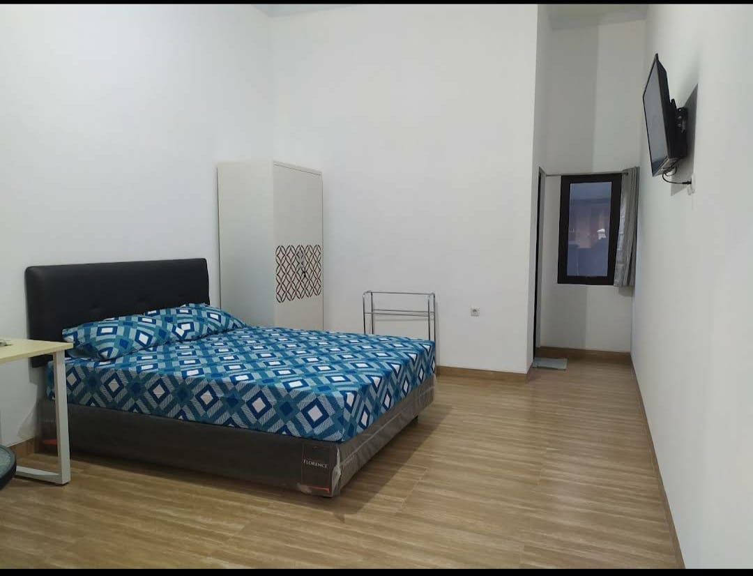 Bedroom with a double bed, blue patterned bedspread, and a nightstand